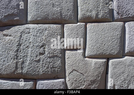 Inca wall made of natural volcanic stones, perfectly shaped, heritage of Inca history and architecture in Cusco, Peru. Backgroun Stock Photo