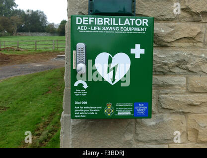 Defibrillator life-saving equipment on village hall in Northumberland, England Stock Photo