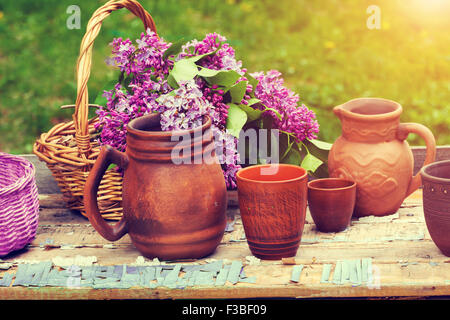 Clay utensil on retro wooden table in the garden Stock Photo