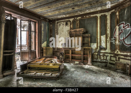 Broken and vandalized piano in an abandoned manor Stock Photo