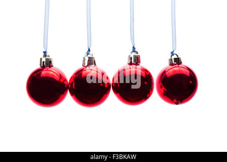 Four red christmas balls hanging in a horizontal row isolated on white background Stock Photo