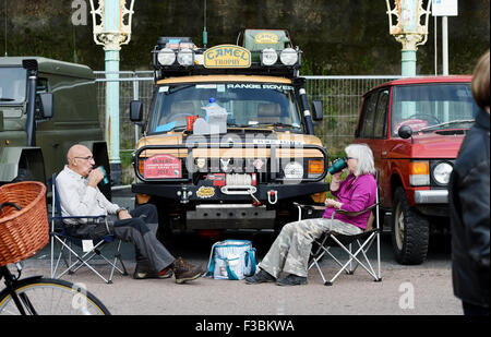 Brighton UK Sunday 4th October 2015 - This couple enjoy a cup of tea in front of their vehicle as Hundreds of Land Rover and Range Rover owners take part in the 17th London to Brighton Land Rover Run which finished on Madeira Drive on the seafront  Credit:  Simon Dack/Alamy Live News Stock Photo