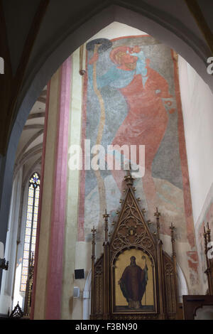 Saint Christopher depicted in the medieval mural from around 1400 in the Church of the Presentation of the Blessed Virgin Mary of the Dominican Monastery in Ceske Budejovice, South Bohemia, Czech Republic. The figure of Saint has almost 32 feet (10 metres) and this is the largest depiction of Saint Christopher in the Czech Republic. Stock Photo