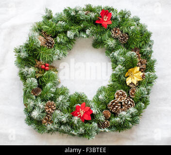Christmas Wreath with pine cones resting on artificial snow Stock Photo
