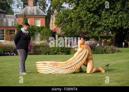 Newport House, Almeley, Herefordshire UK - Sunday 4th October 2015 - Visitors enjoy the opening day of  the Out of Nature sculpture exhibition featuring over 200 pieces of work from 40 artists displayed in the formal gardens of Newport House. This piece is titled Greer Guardian Angel by artist Ed Elliot and made from cedar wood. Stock Photo