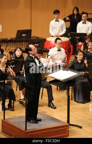 Singapore. 4th Oct, 2015. Maestro He Zhanhao (front) conducts a charity concert in Singapore, Oct. 4, 2015. Organized by Business School, National University of Singapore (NUS) and Chinese Music Academy in Singapore, a charity concert bringing the masterpiece 'Butterfly Lovers Concerto' was held here on Sunday to raise money for financially-needy students to further their educational pursuits. Meanwhile, the concert also celebrated Singapore's golden jubilee as well as the 25th anniversary of China-Singapore diplomatic relations. © Bao Xuelin/Xinhua/Alamy Live News Stock Photo