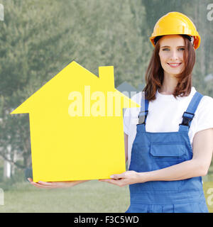 Happy female worker holding a house model Stock Photo