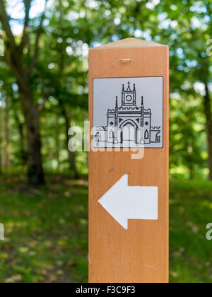 Wooden marker post, showing the castle gate on a path in the Deer Park at Auckland Castle Stock Photo