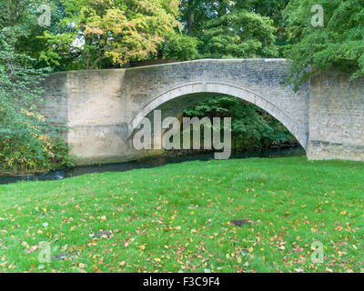 An 18th century stone bridge over a stream in the Deer Park at Auckland Castle, built by Bishop Trevor in 1757 Stock Photo