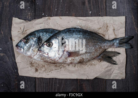 Two raw fishes on the crumpled paper Stock Photo