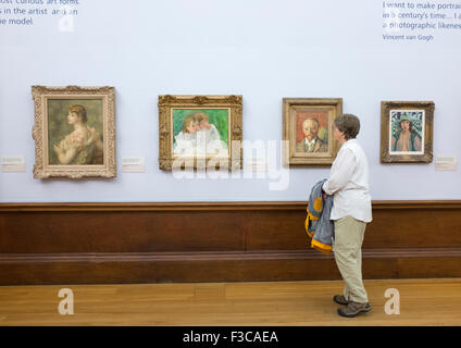 Visitor looking at paintings on display at Kelvingrove Art Gallery and Museum in Glasgow United Kingdom Stock Photo