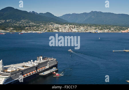 Cruise ship parked at Canada Place in Vancouver harbour. Seabus traveling across Burrard Inlet to North Vancouver.  Mountains. Stock Photo