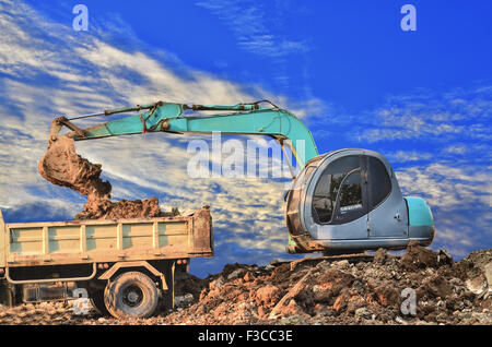 Excavator loading dumper truck tipper in sandpit Stock Photo