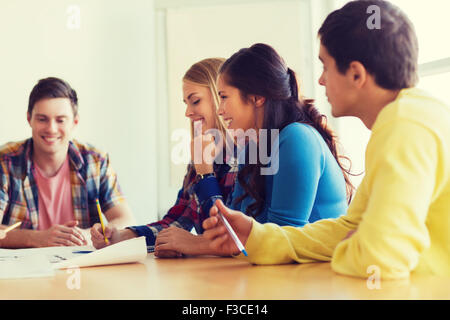 group of smiling students with blueprint Stock Photo