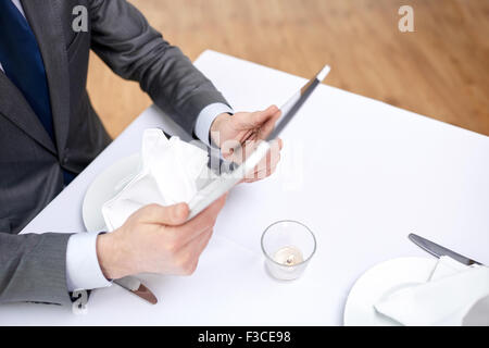 close up of man with tablet pc at restaurant Stock Photo