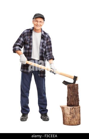 Full length portrait of a senior man in a checkered shirt splitting a log with an ax isolated on white background Stock Photo