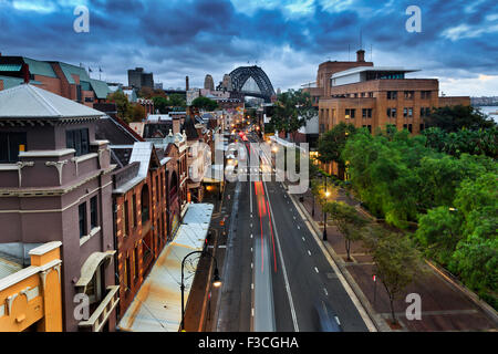 Sydney's The Rocks historic residential district and suburb at sunset from above position with lights on and Harbour bridge Stock Photo