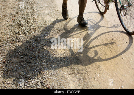Tuscany, Italy. 4th Oct, 2015. The shadow of a cyclist is seen on the gravel road during the 'Eroica' cycling event for old bikes in the Chianti area of Tuscany, Italy, on Oct. 4, 2015. More than 6,000 cyclists from 66 countries, wearing vintage cycling jerseys, riding vintage bicycles built in 1987 or earlier, took part in the 'Eroica'(heroic) cycling event through the 'Strade Bianche', the gravel roads of the Chianti area of Tuscany. © Jin Yu/Xinhua/Alamy Live News Stock Photo
