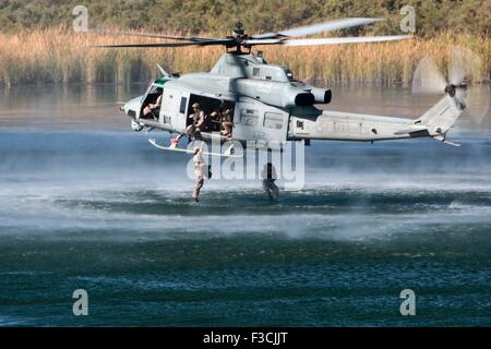 US Marine special forces commandos with 1st Force Reconnaissance Company, jump from a UH-1Y Venom helicopter into Ferguson Lake during insertion training called helocasting October 3, 2015 near Yuma, Arizona. Stock Photo