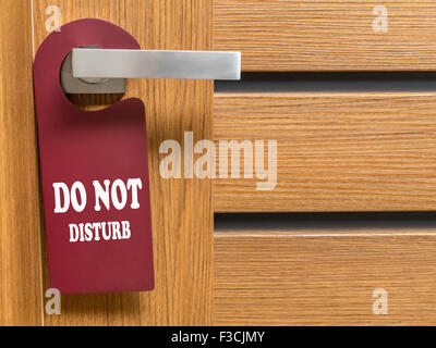 Do Not Disturb door hanger hanging on hotel room door handle Stock Photo