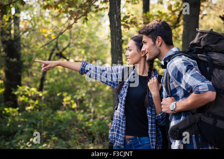 Portrait of a woman pointing on something to her boyfriend in forest Stock Photo