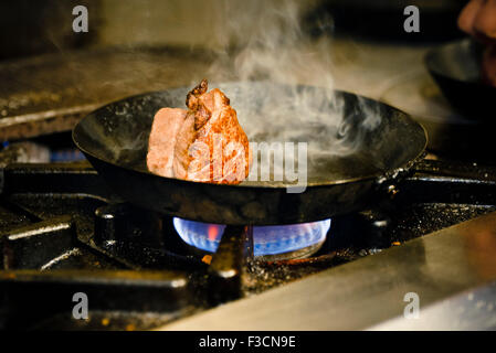 Meat cut browning in pan Stock Photo