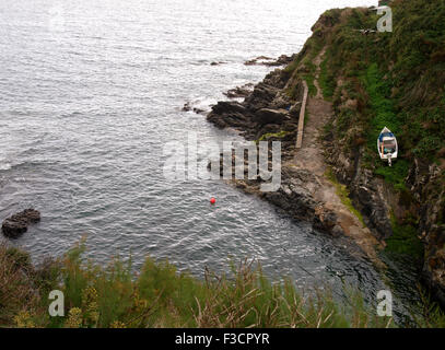 Small fishing boat pulled up from the sea using old manual winch at top of hill, Near Perranuthnoe, Cornwall, UK Stock Photo