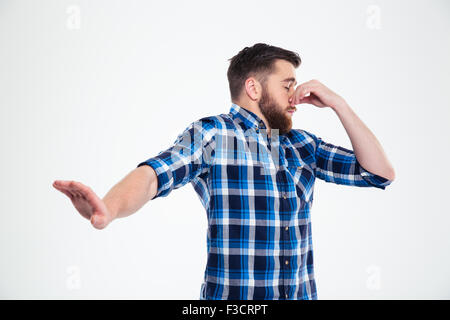 Portrait of a casual man covering his nose and showing stop gesture with palm isolated on a white background Stock Photo