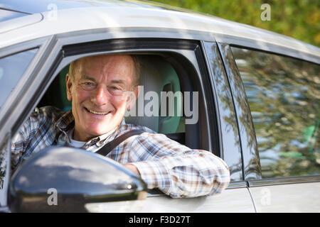 Portrait Of Smiling Senior Man Driving Car Stock Photo