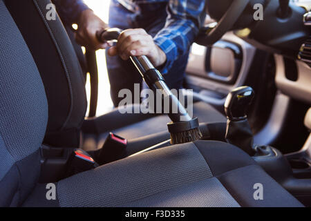 Man Hoovering Seat Of Car During Car Cleaning Stock Photo
