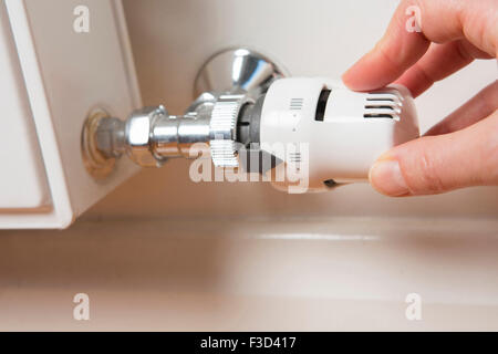 Close Up Of Hand Adjusting Radiator Thermostat Stock Photo