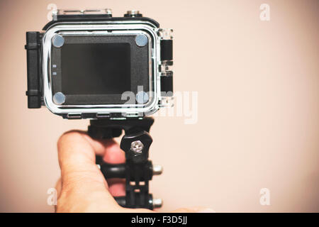 Small action camera in hand ready for snorkeling and diving with the use of waterproof case from back and front. Very popular ga Stock Photo