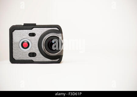 Very small action camera, popular gadget for adventure and capturing adrenalin moments. Camera is set on white background. Stock Photo