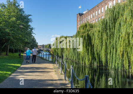 Elderly Couple Walking on Riverside Path beside St James Mill Norwich Norfolk UK Stock Photo