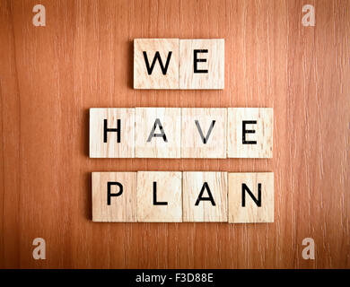 We have Plan text on tiles over wooden background Stock Photo