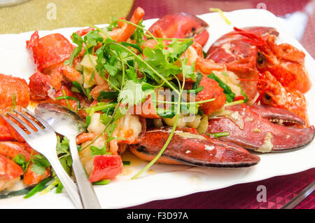 Plate of lobster fried on a wok with coriander Stock Photo