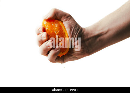 man dramatic squeezes orange. Concept squeezed a man  is tired from work. Stock Photo