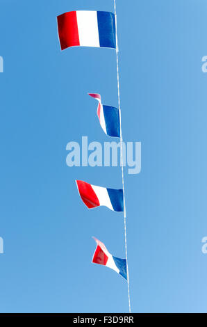 Four French flags on a blue sky background Stock Photo