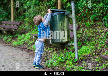 Little child throwing trash in the bin Stock Photo