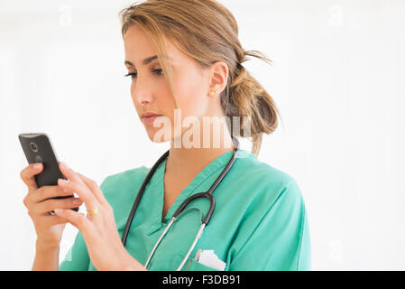 Young female doctor using smart phone Stock Photo