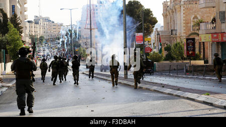 Israeli soldiers charge into the streets of the West Bank city of Bethlehem, firing tear gas at Palestinian demonstrators, following the death of a Palestinian child who was killed by Israeli soldiers. Following the killing of a 12-year-old Palestinian child, Abed al-Rahman Shadi Obeidallah, from Aida Refugee Camp, by Israeli soldiers, in Bethlehem, West Bank Palestinian youth took to the streets of Bethlehem and clashed with Israeli soldiers. The soldiers charged into the streets of the city, firing hundreds round of tear gas, rubber-coated steel bullets, and live fire. Four Palestinian youth Stock Photo