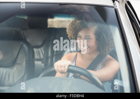 Young woman smiling while driving car