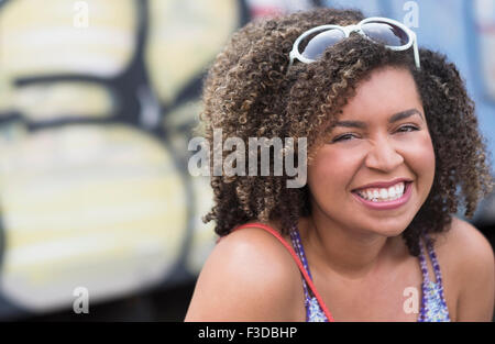 Portrait of smiling young woman with curly hair Stock Photo
