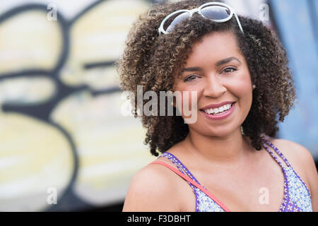 Portrait of smiling young woman with curly hair Stock Photo