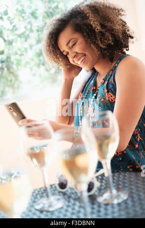 Young woman using smart phone at restaurant Stock Photo