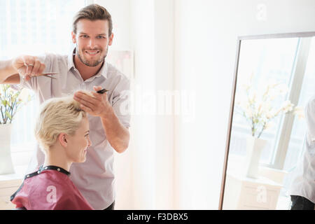 Portrait of hairdresser cutting woman's hair Stock Photo