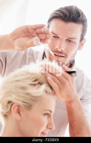 Hairdresser cutting woman's hair Stock Photo