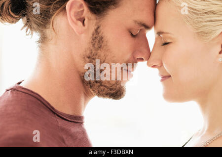 Couple rubbing noses on white background