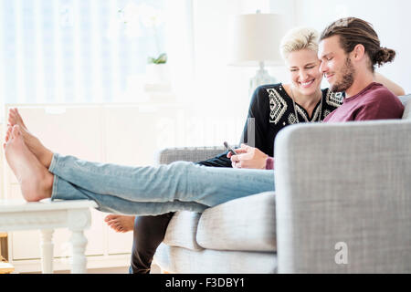 Couple laughing on sofa Stock Photo