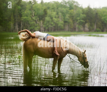 Woman horseback riding in countryside Stock Photo